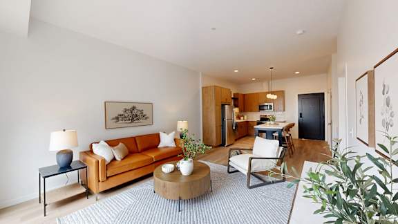 A living room with a couch, a coffee table, and a lamp.