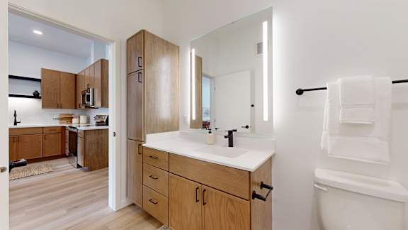 A bathroom with a white sink and a large mirror.