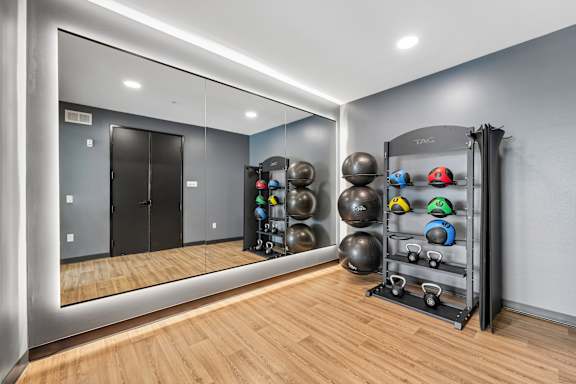 A gym with a mirror, weights, and a rack.