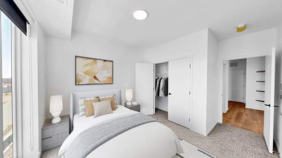 A bedroom with a large bed and a painting on the wall.