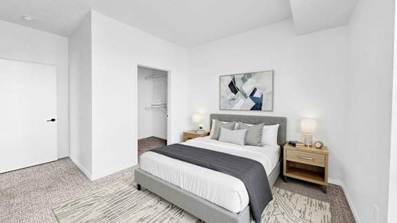 A bedroom with a large bed and a painting on the wall.