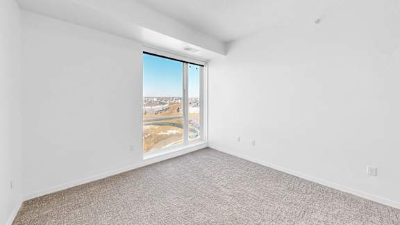 A room with a large window overlooking a snowy landscape.