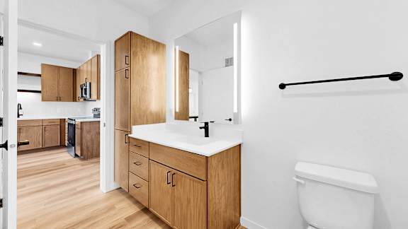 A bathroom with a white sink and a white toilet.