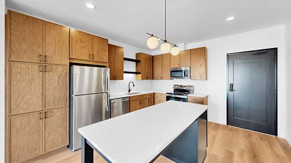 A modern kitchen with wooden cabinets and stainless steel appliances.