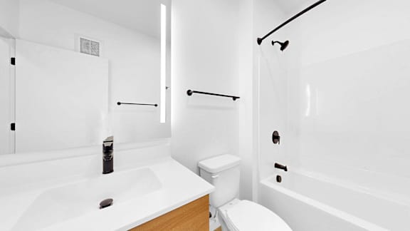 A white bathroom with a toilet, sink, and bathtub.