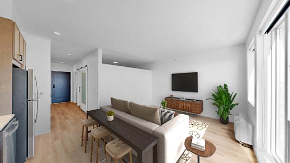 A modern living room with a couch, a coffee table, and a television.