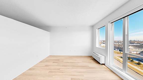 A room with a window overlooking a residential area.
