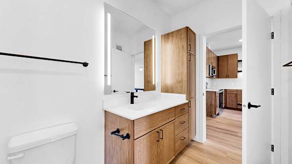 A bathroom with a white tub and wooden cabinets.