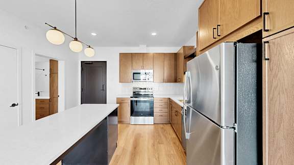 A modern kitchen with a refrigerator on the right.