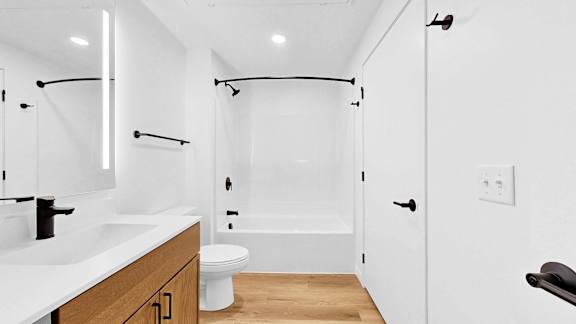 A white bathroom with a toilet, sink, and bathtub.
