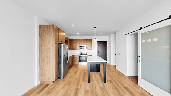 A modern kitchen with wooden cabinets and a white countertop.