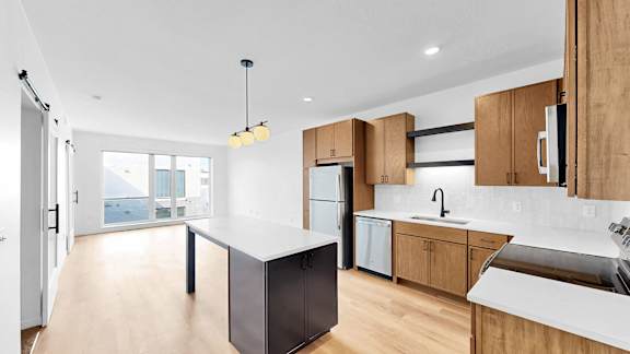 A modern kitchen with wooden cabinets and a white island.