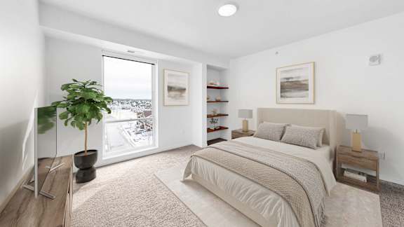 A bedroom with a large bed and a potted plant.