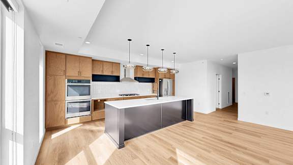 A modern kitchen with wooden cabinets and a large island.