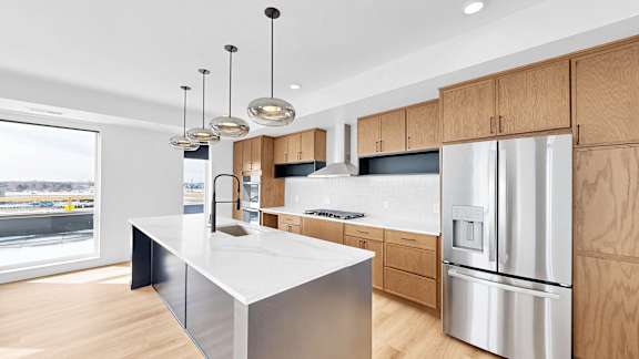 A modern kitchen with a large island and stainless steel appliances.