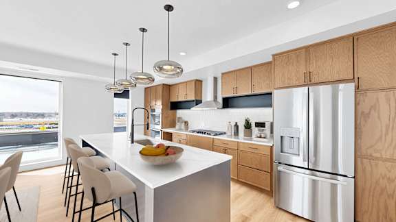 A modern kitchen with a large island and stainless steel appliances.