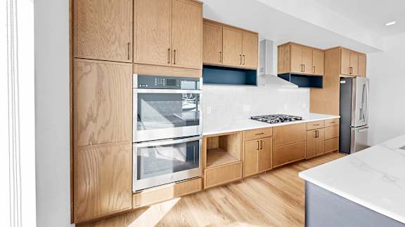 A modern kitchen with wooden cabinets and stainless steel appliances.