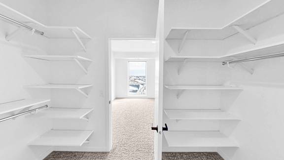 A white interior with a doorway leading to a balcony.