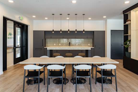 A modern dining room with a long table and chairs.