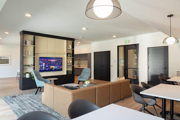 A modern living room with a large TV and comfortable seating.