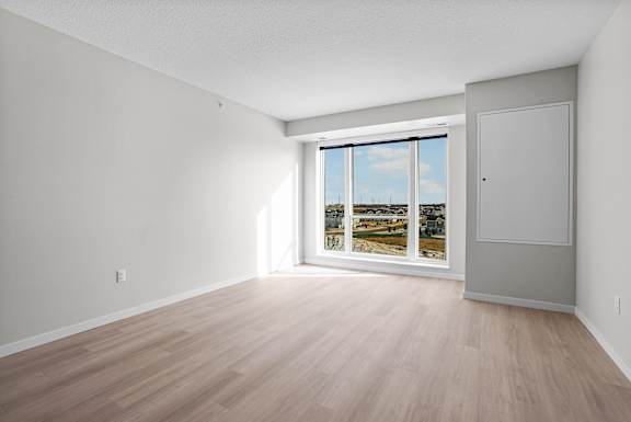 A room with a sliding glass door leading to a balcony.