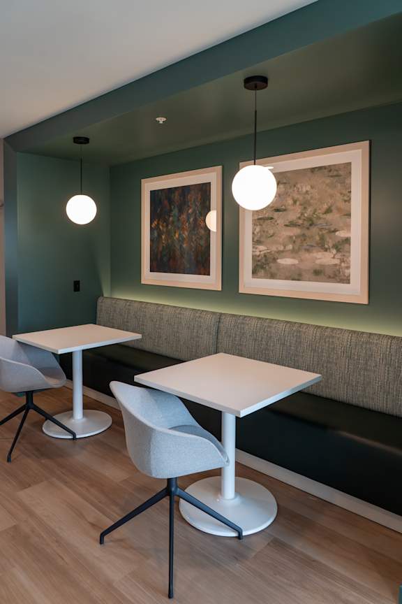A room with a green wall and a white table and chairs.