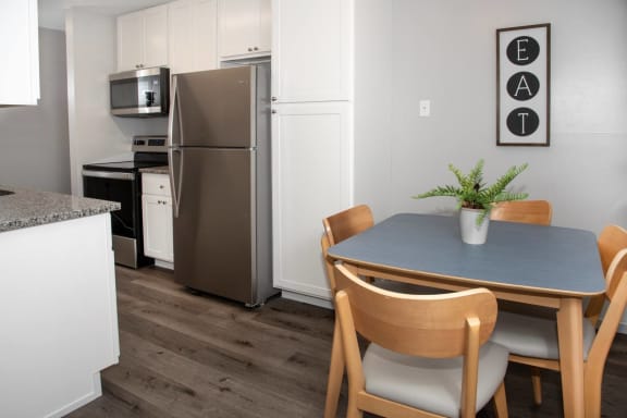kitchen and dining with new white cabinetry, granite countertops, stainless steel appliances