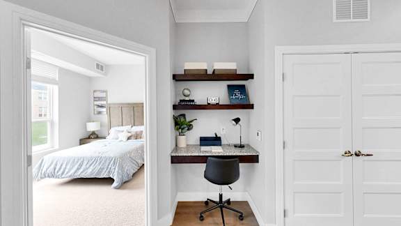A bedroom with a bed, desk, and chair.