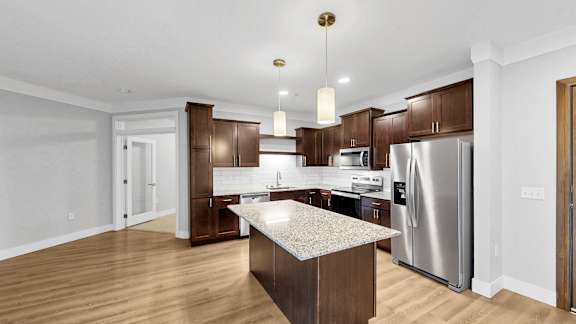 A modern kitchen with wooden cabinets and stainless steel appliances.
