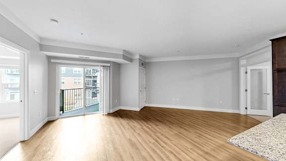 A spacious room with wooden floors and white walls.