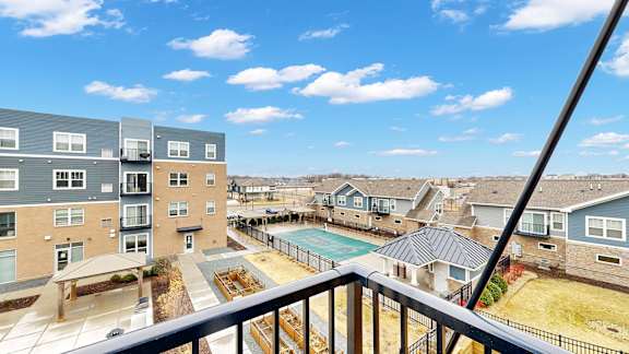 A view from a balcony overlooking a pool and apartment buildings.