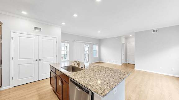 A kitchen with a granite countertop and stainless steel appliances.