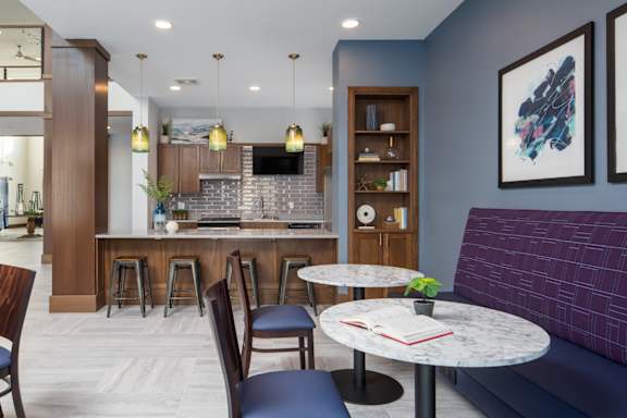 A modern kitchen with a bar area and seating.at The Edison at Spirit, Lakeville, MN 55044