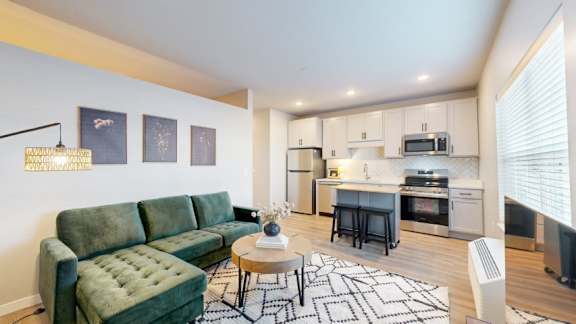 A living room with a green couch and a coffee table.