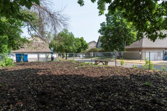 a park with a picnic table in front of a chain link fence
