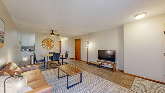 A living room with a brown couch, a wooden coffee table, and a flat screen TV.