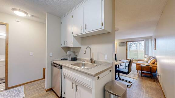 A kitchen with white cabinets and a stainless steel dishwasher.