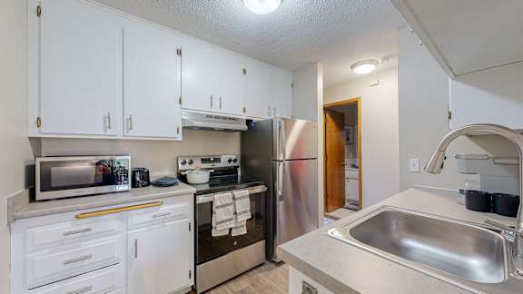 A kitchen with white cabinets and stainless steel appliances.