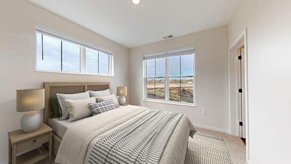 A bedroom with a large bed and a view of the beach.