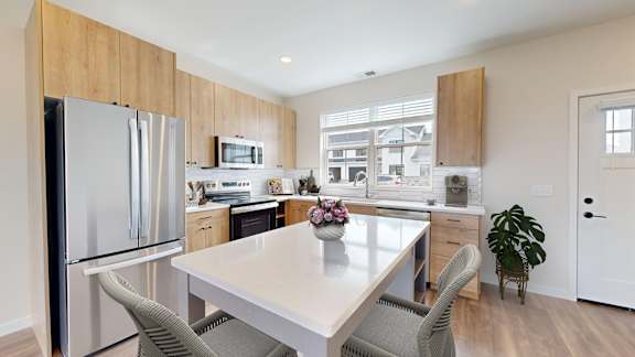 A modern kitchen with a dining table and chairs.