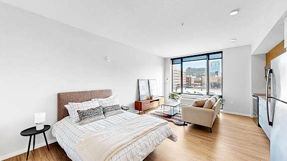 A bedroom with a large bed and a view of the city.
