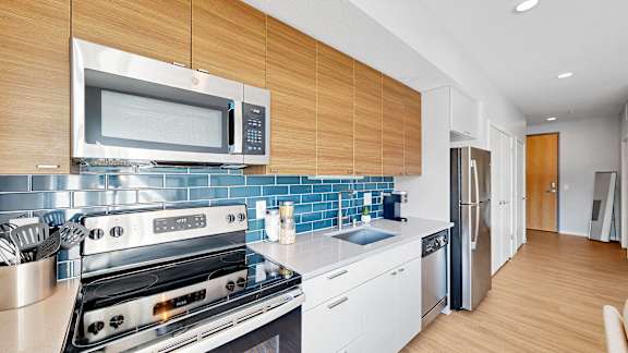 A modern kitchen with a stove top oven and microwave above it.