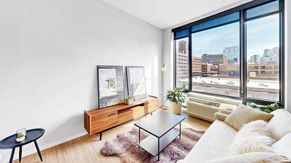 A modern living room with a large window overlooking the city.