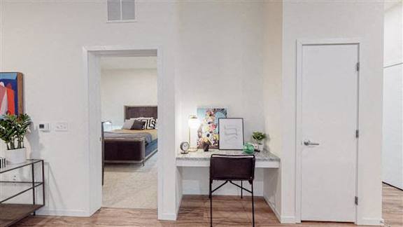 A room with a desk, chair, and bed at The Bessemer at Seward Commons Apartments, Minneapolis