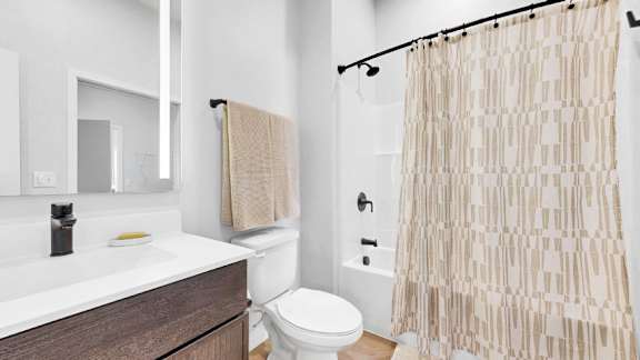 A bathroom with a toilet, sink, and shower curtain.