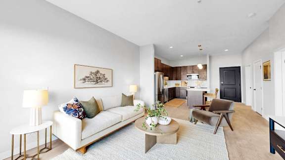 A living room with a white couch, a coffee table, and a painting on the wall.