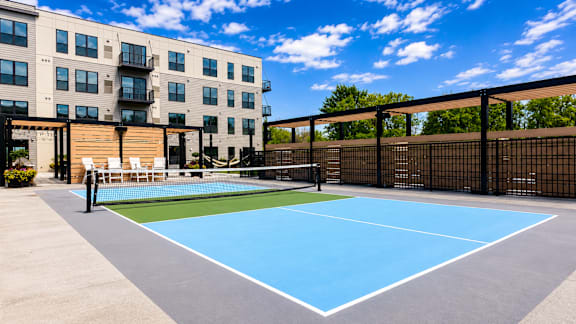 A tennis court is located in front of a building.