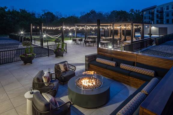 A patio with a fire pit and seating area.