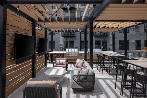 A patio with a table and chairs under a roof.