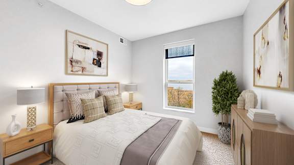 A bedroom with a large bed, a nightstand, and a window.